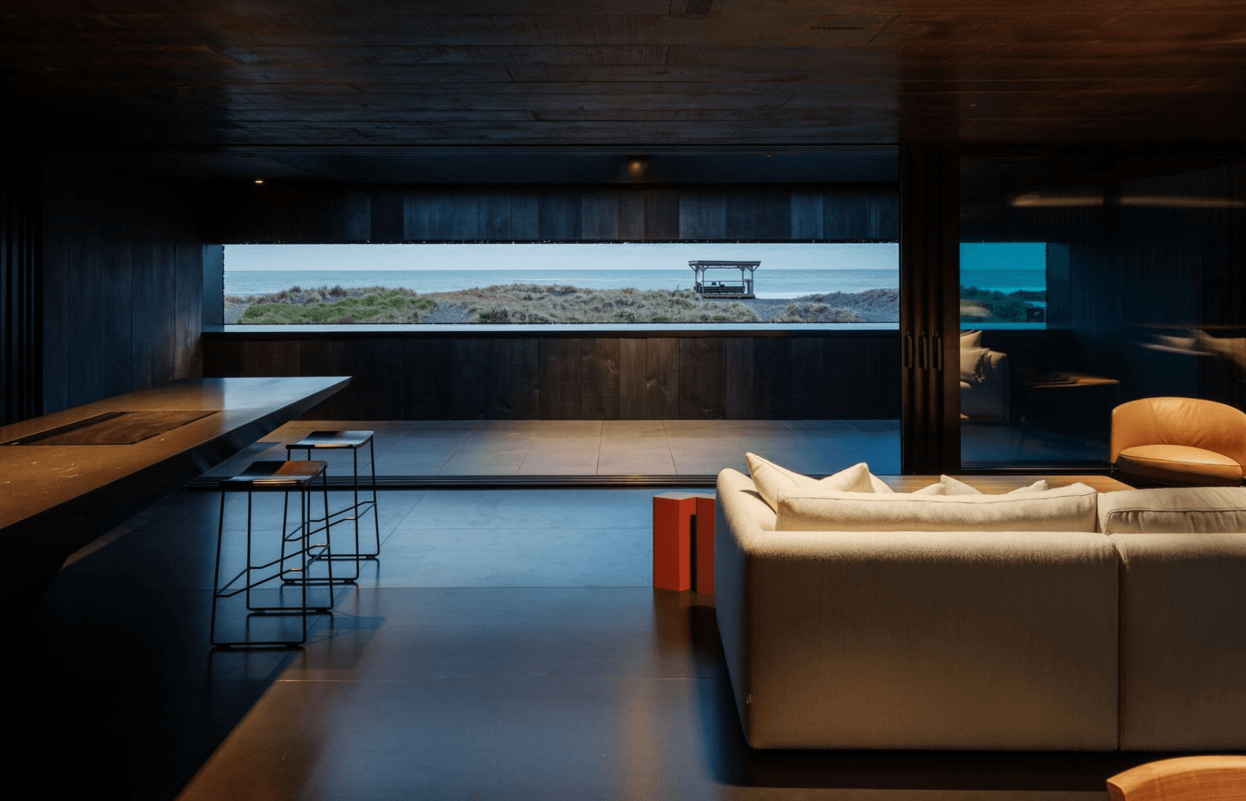 Dramatic modern interior with horizontal window framing ocean and dune views