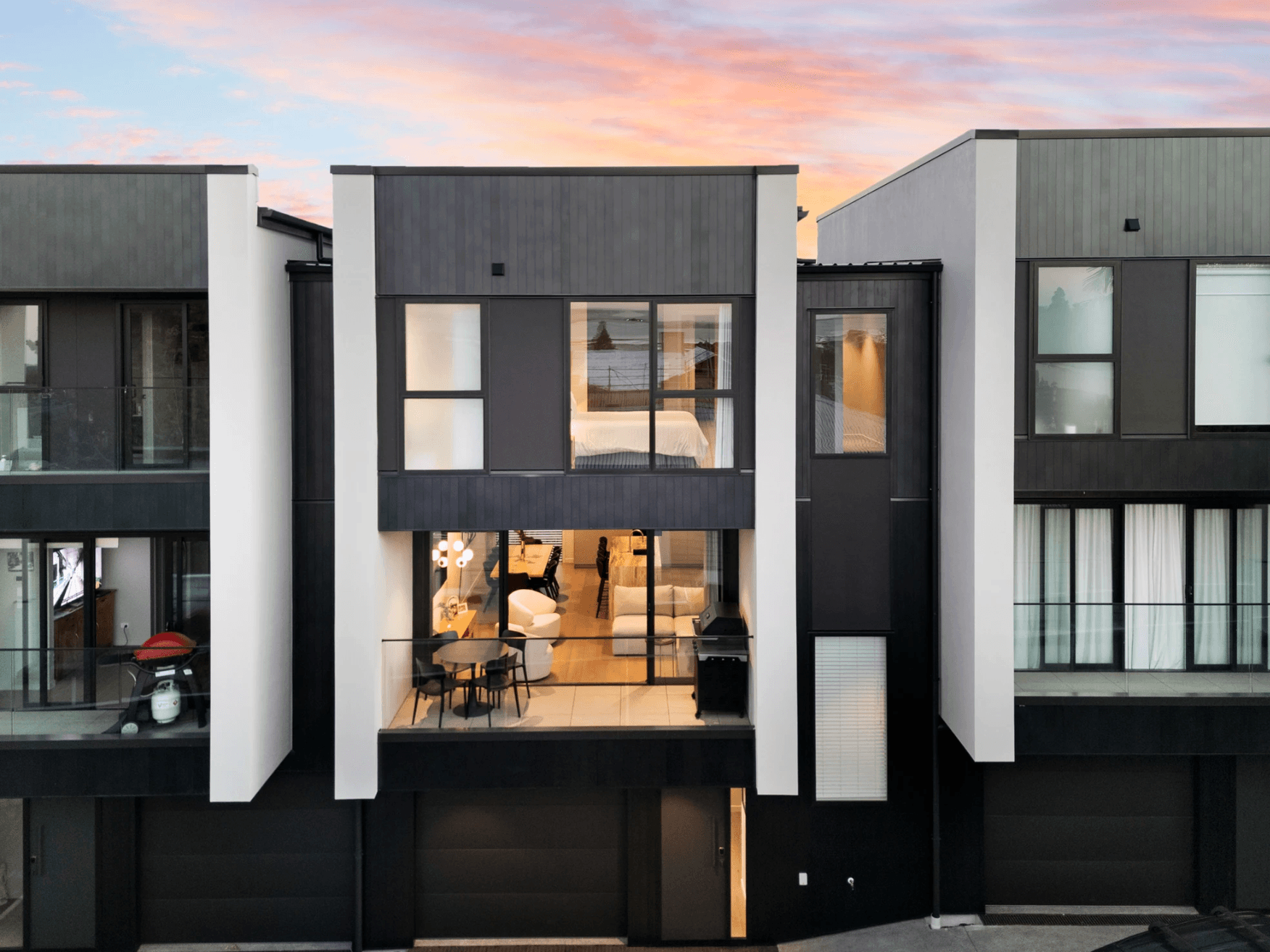 Modern townhouse exterior at sunset with an elevated tiled deck built on the Nurajacks pedestal system